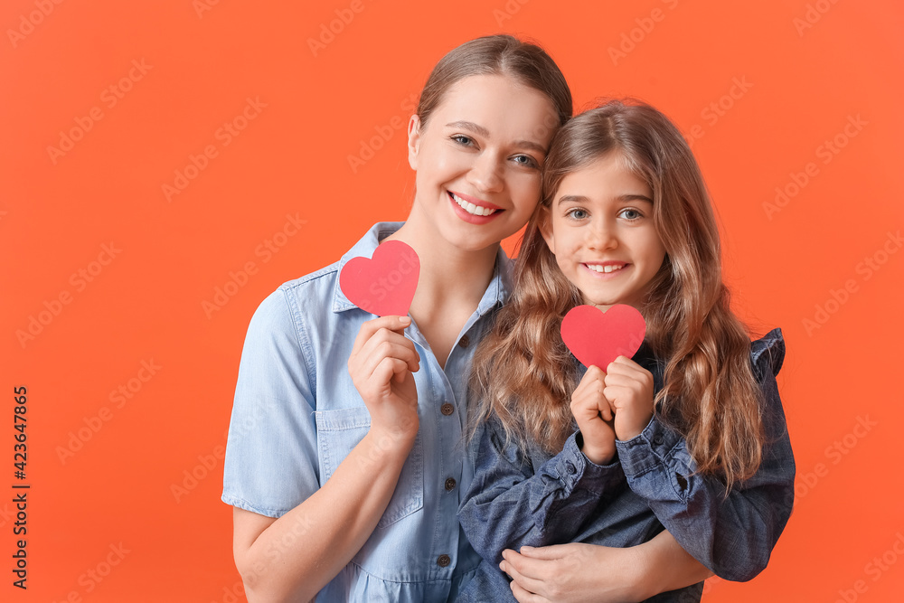 Happy woman and her little daughter with red hearts on color background Happy woman and her little daughter with red hearts on color background