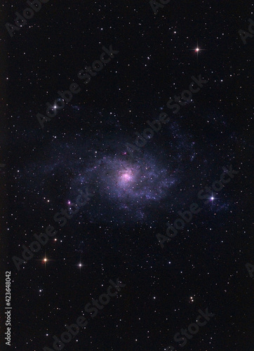 M33 galaxy photographed with long exposure through a telescope.