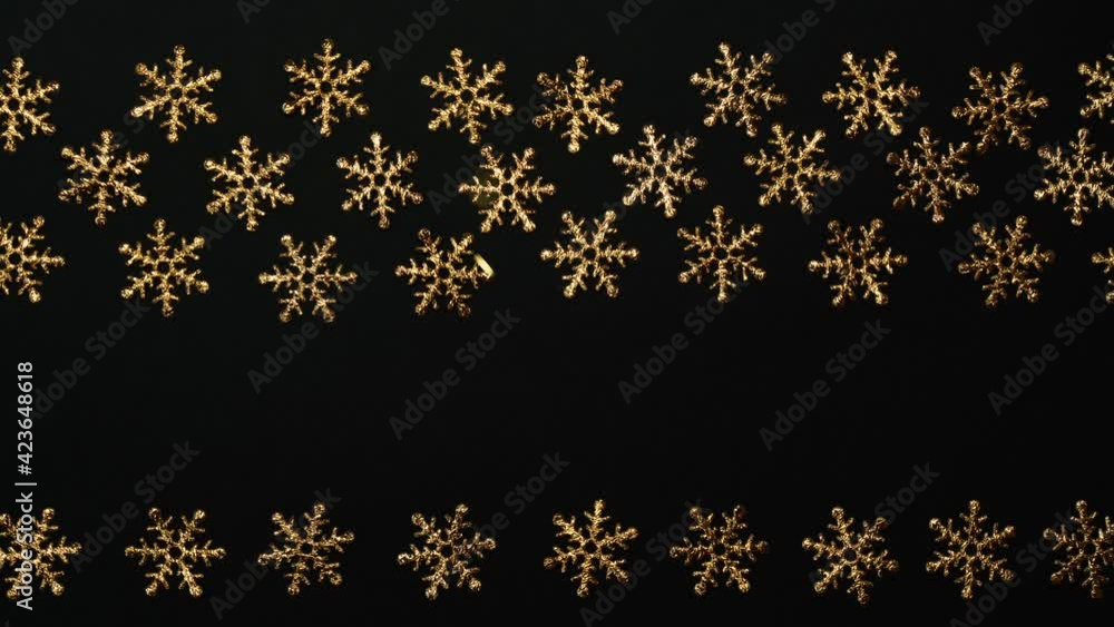 Christmas ornament frame on black, golden snow flakes , flying glitter particles Christmas ornament frame on black, golden snow flakes , flying glitter particles
