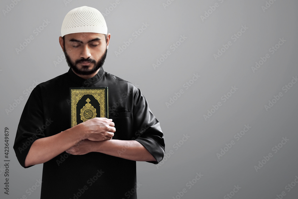 Religious asian muslim man holding holy quran Stock Photo | Adobe Stock