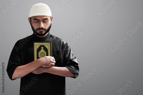 Religious asian muslim man holding holy quran © fotokitas