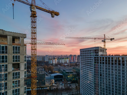 New concrete houses with construction cranes