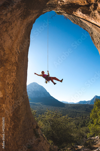 Rock climber descends from the route, the climber hangs on a rope