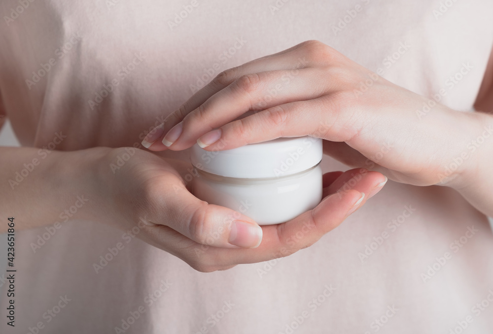 Woman hands holding cosmetic cream in glass jar. Skincare, moisturizing, beauty concept. Close up Woman hands holding cosmetic cream in glass jar. Skincare, moisturizing, beauty concept. Close up