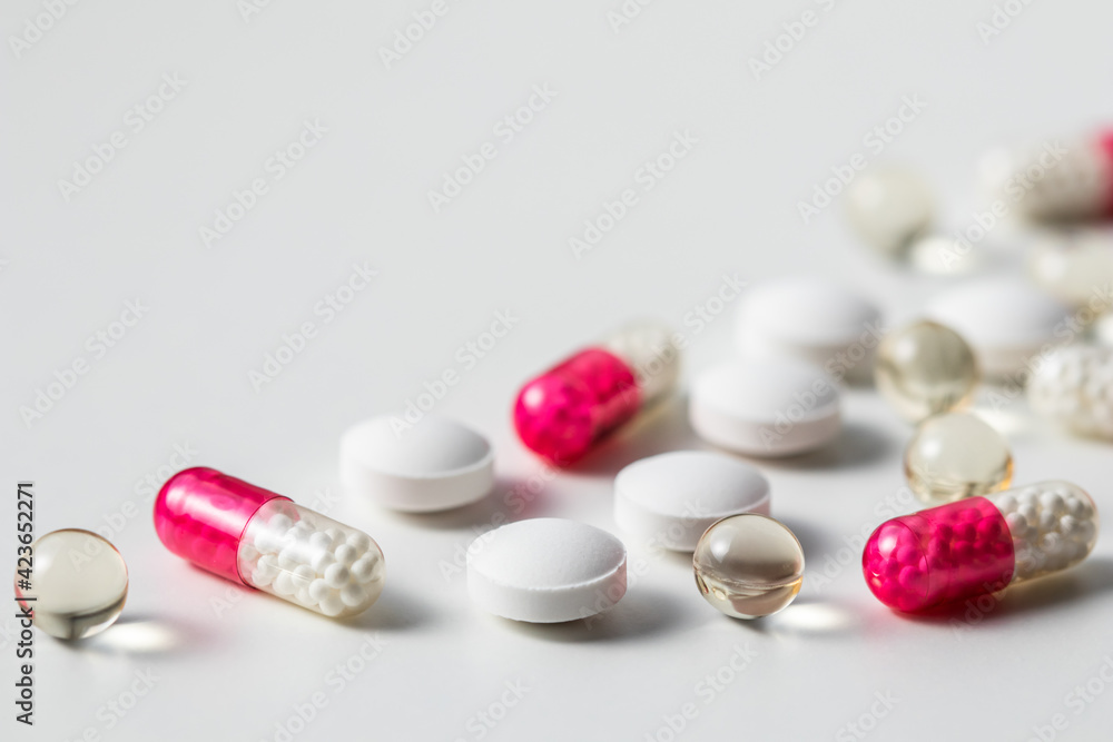 Red capsules and pills on a white background. Health care, medical, pharmacy and illness concept Red capsules and pills on a white background. Health care, medical, pharmacy and illness concept