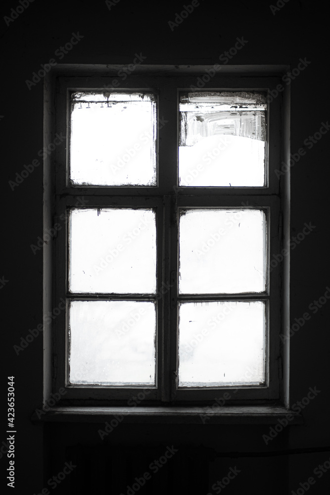 Textured silhouette of an old wooden window in dark abandoned interior. Textured silhouette of an old wooden window in dark abandoned interior.