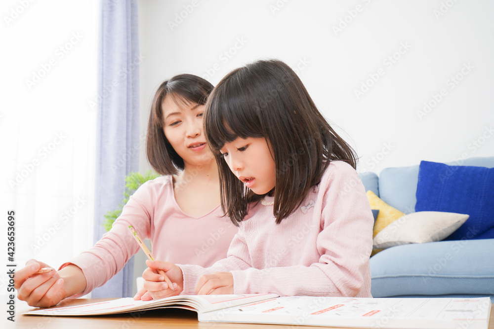 お家でお勉強をする女の子とお母さん お家でお勉強をする女の子とお母さん