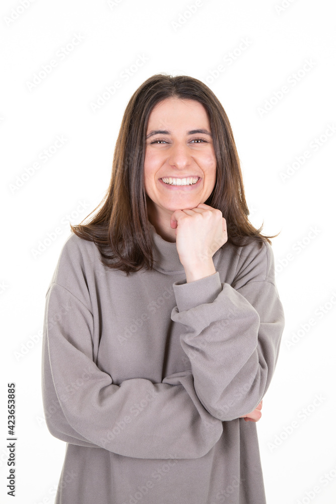 beautiful young cheerful woman with hand under chin happy and smiling with long brown hair beautiful young cheerful woman with hand under chin happy and smiling with long brown hair
