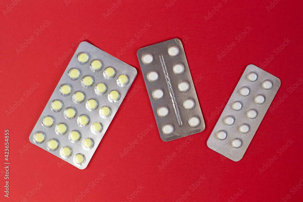 Group of colorful pills as nice bright red textured background Narrow focus line, shallow depth of field Group of colorful pills as nice bright red textured background Narrow focus line, shallow depth of field