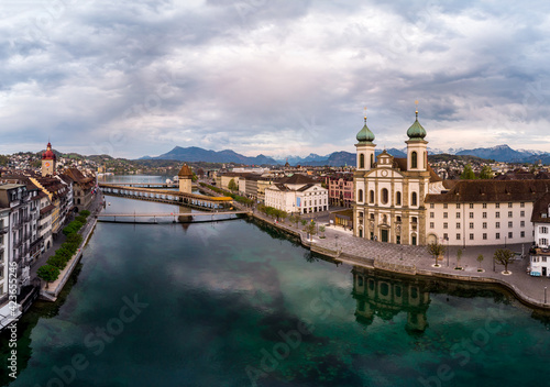 Dramatic aerial view of the Reuss river in the heart of Lucerne old town with the Jesuit church and the chapel's bridge in Switzerland