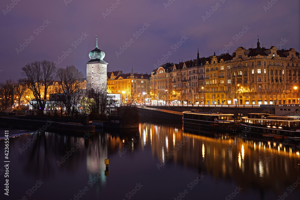 Historic Prague city center in night, lights mirroring in river, Manes landmark, Prague, Czech Republic