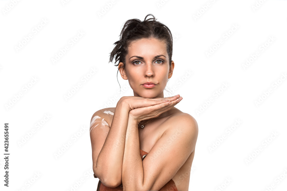 Obraz premium Studio portrait of a beautiful adult woman with brown hair gathered in a tousled bun. Folded palms. Pretty girl artist model with perfect fresh clean skin. She is wearing an artist's leather apron. 