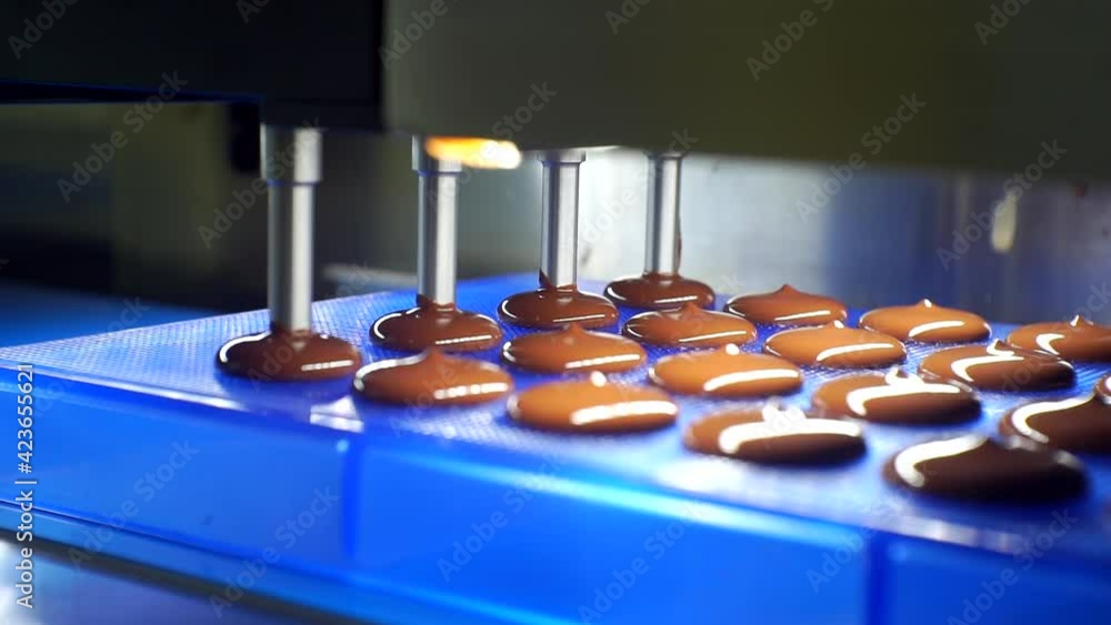 liquid chocolate mass is poured from the machine. close-up liquid chocolate mass is poured from the machine. close-up