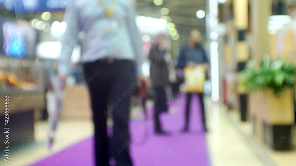 Blurred silhouettes of unrecognizable people in a large bright hall. Blurred silhouettes of unrecognizable people in a large bright hall.
