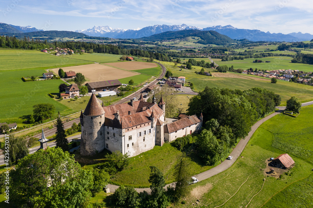 Aerial view of the medieval Oron castle, dating back to the 13th century, in Canton Vaud with the alps in the background in Switzerland