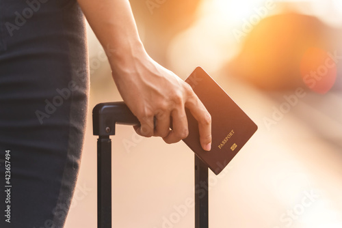 Young womane tourist hand holding passport at train station,Travel abroad concept. photo