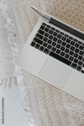 Flatlay of laptop on wicker bench. Flat lay, top view minimalist home office workspace. photo