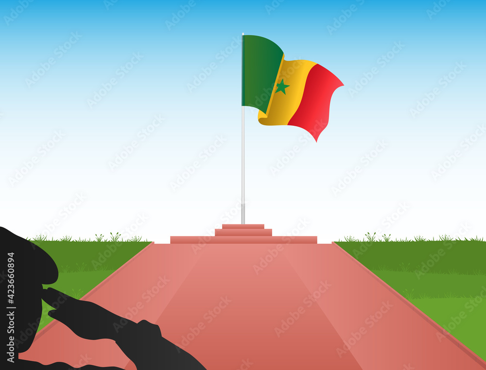 The flag of Senegal flies above the pole in the shadow of a soldier saluting the flag