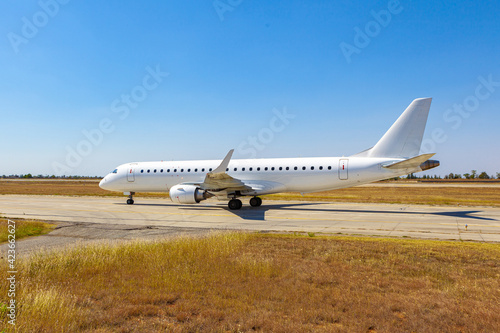 Big passenger airplane drives along the runway in airport