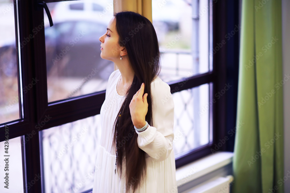 Relaxed serene pretty young woman at home, happy calm lady dream enjoy wellbeing breathing fresh air in cozy home Relaxed serene pretty young woman at home, happy calm lady dream enjoy wellbeing breathing fresh air in cozy home