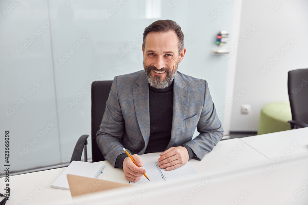 Happy adult caucasian man is working in a modern office Happy adult caucasian man is working in a modern office