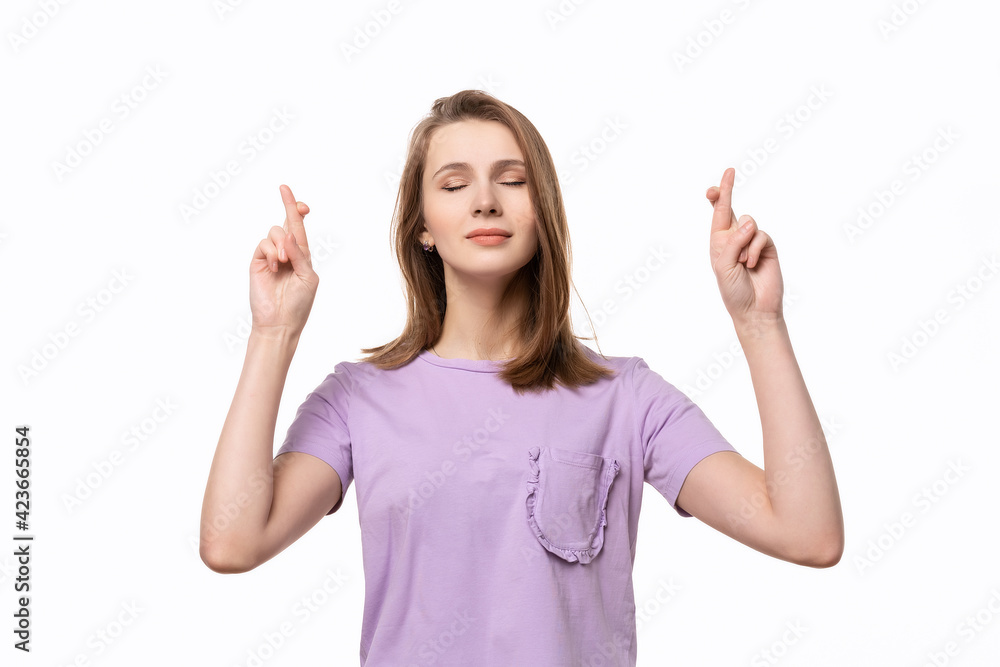Attractive girl student crosses fingers with big hope and prays for good luck during exam, isolated on white background Attractive girl student crosses fingers with big hope and prays for good luck during exam, isolated on white background