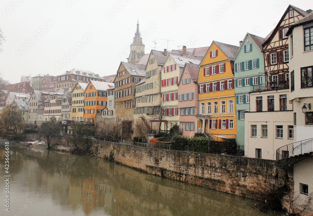 Neckar front on a snowy winter day in Tübingen, Baden-Württemberg, Germany. Beautiful landscape with colorful houses and a light snowfall
