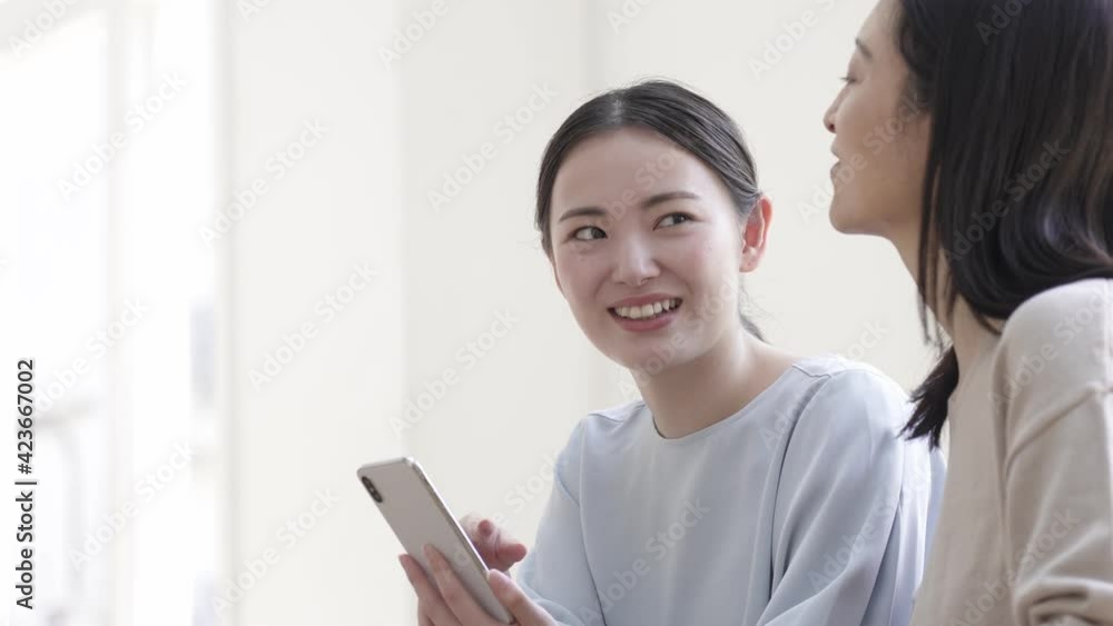 笑顔でスマホを見る母と娘 笑顔でスマホを見る母と娘