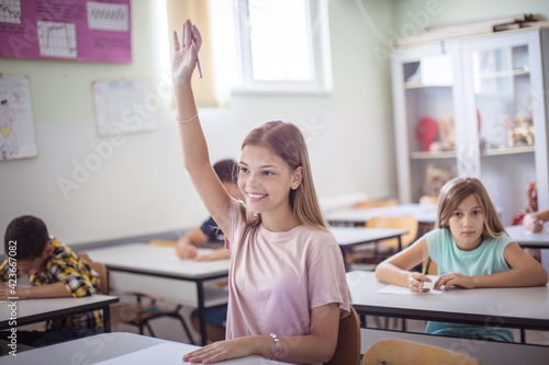 School kid raise hand.  Teenagers students sitting in the classroom.