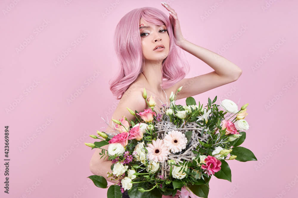 Woman with colored pink strong hair holds a bouquet of beautiful flowers in her hands. Natural dyed hair beautiful makeup, strong roots Woman with colored pink strong hair holds a bouquet of beautiful flowers in her hands. Natural dyed hair beautiful makeup, strong roots