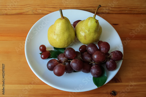 Two yellow pears and purple grapes.