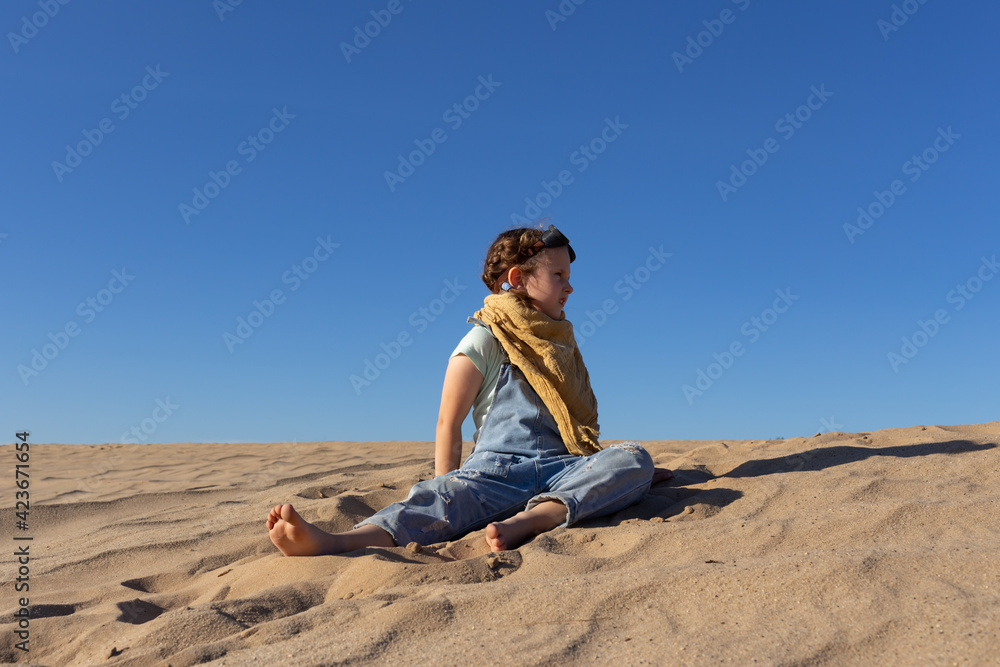 Little kid girl in goggles in sand desert Little kid girl in goggles in sand desert