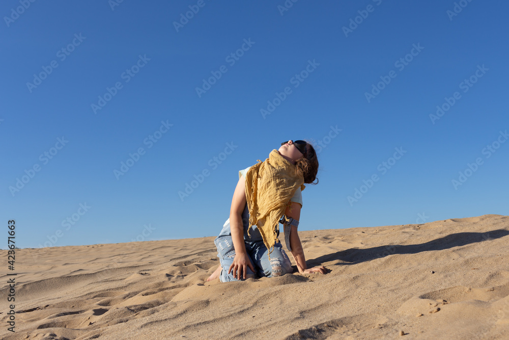Little kid girl in goggles in sand desert