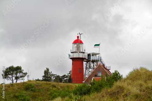 The red lighthouse and next to it the lighthouse keeper's house in het dunes of the Dutch island of Vlieland
