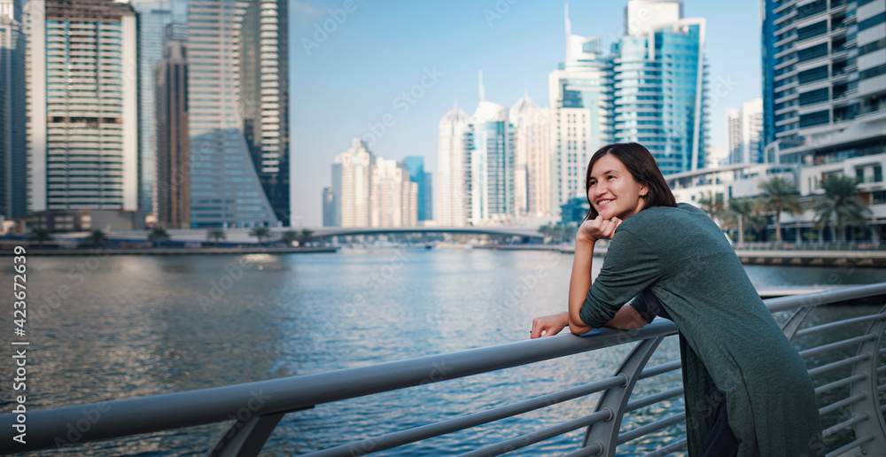 Happy young female traveler in the big city of Dubai, UAE Happy young female traveler in the big city of Dubai, UAE