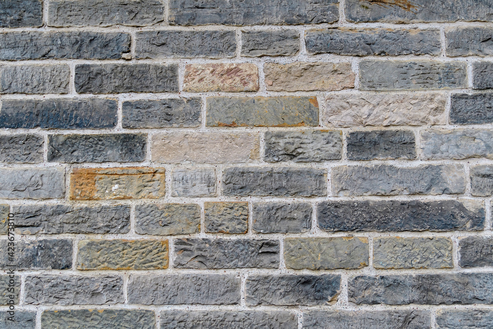 Minimalist textured monochrome background of old grey bricks and stones in horizontal display on an old wall in Scotland. Minimalist textured monochrome background of old grey bricks and stones in horizontal display on an old wall in Scotland.