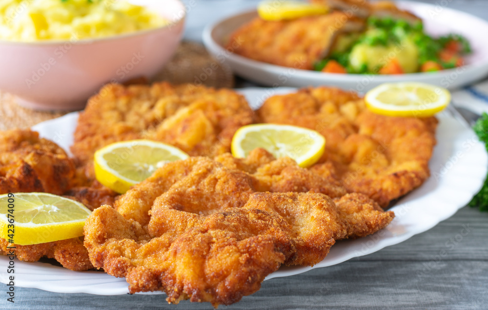 Pork schnitzels on a plate on kitchen table. Homemade cooked Pork schnitzels on a plate on kitchen table. Homemade cooked