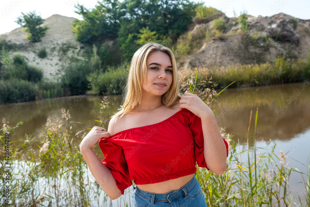 Foto de beautiful young girl in a T-shirt and short shorts posing in ...