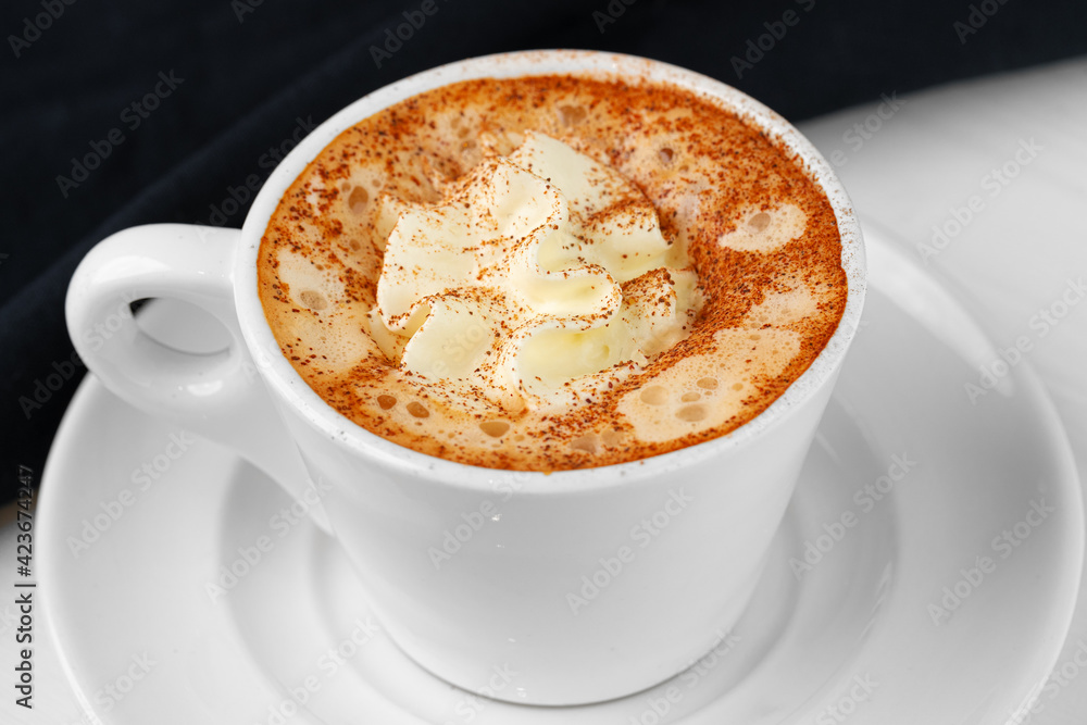 Cup of coffee with whipped cream on white table Cup of coffee with whipped cream on white table