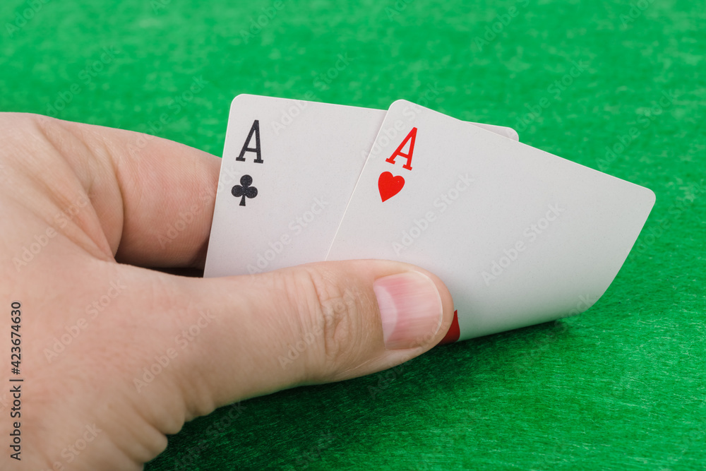 Hand with playing cards in casino