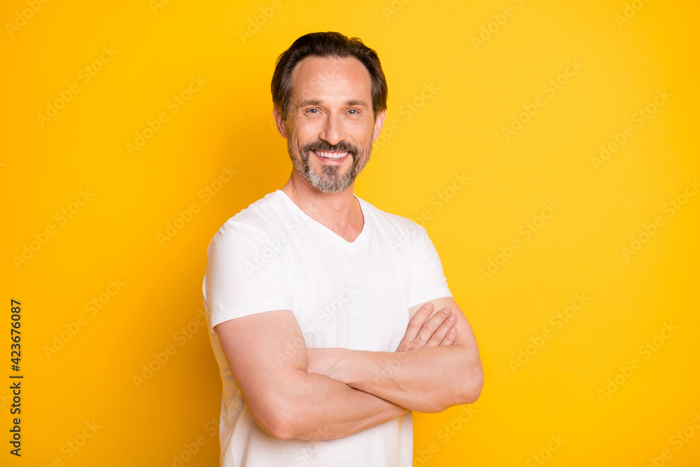 Portrait of attractive content virile cheerful guy folded arms isolated over bright yellow color background Portrait of attractive content virile cheerful guy folded arms isolated over bright yellow color background