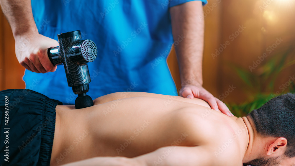 Massage Gun Treatment. Physical Therapist Massaging Man's Lower
