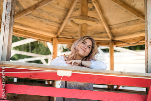 female model posing in wooden gazebo near lake ar sity park