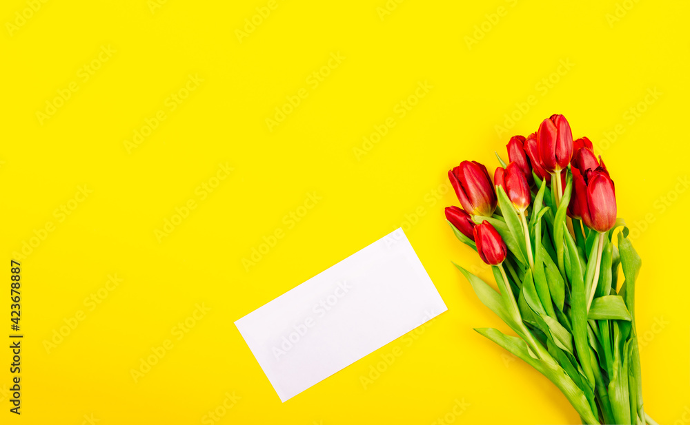 White gift certificate envelope or business card on yellow background with bouquet of red tulips and copy space, empty text place. Holiday greeting card. Happy Valentine Day, Woman Day, Mother Day White gift certificate envelope or business card on yellow background with bouquet of red tulips and copy space, empty text place. Holiday greeting card. Happy Valentine Day, Woman Day, Mother Day