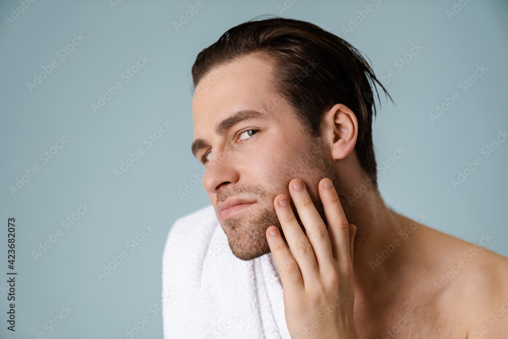 Shirtless white man touching his cheek and looking at camera Shirtless white man touching his cheek and looking at camera