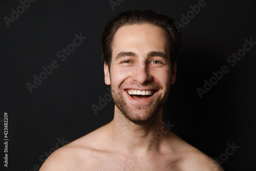 Shirtless white man laughing and looking at camera