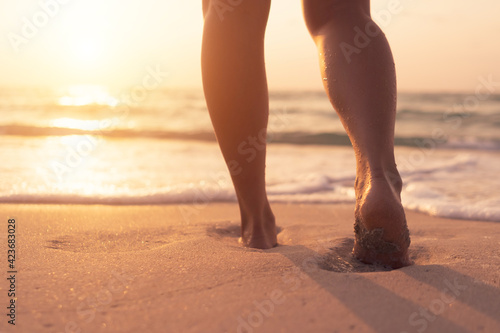 Woman feet walk slow life and relax on sand tropical beach with blue sky.