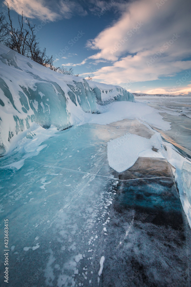 Obraz premium The frozen lake Torneträsk in Swedish Lapland. Beautiful ice forms create an amazing sight.