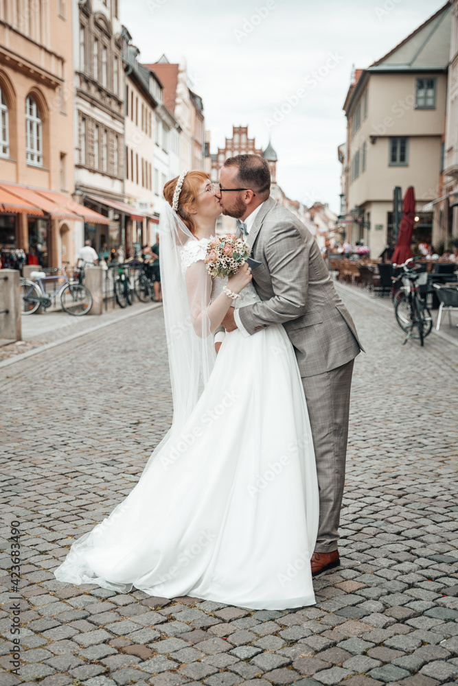 Bridal couple kissing in the middle of the street
