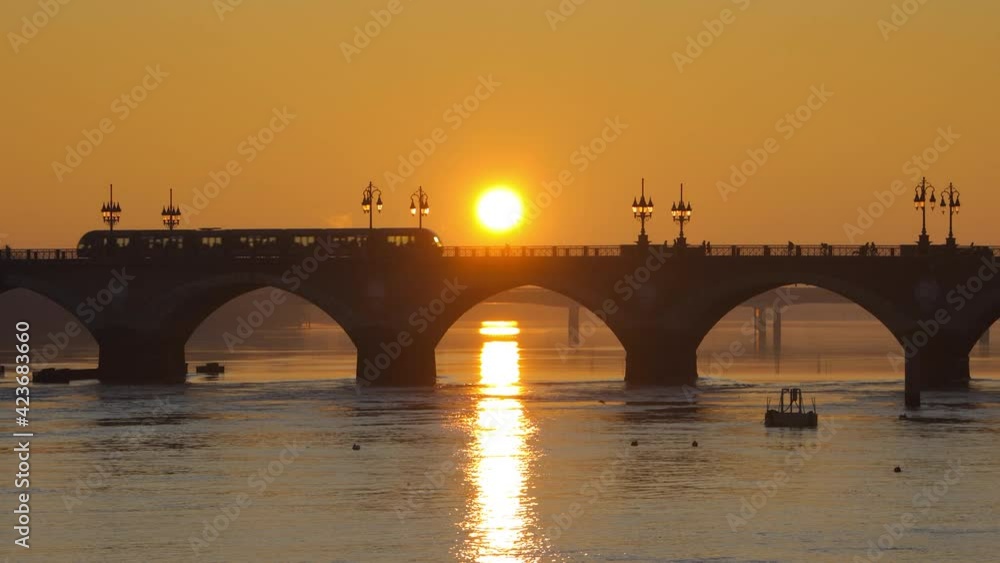 Pont de Pierre bridge at sunrise in Bordeaux, France with a tram crossing the bridge